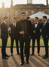 Group of men in formal attire standing outdoors with a large building in the background.