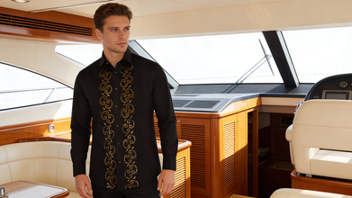 Man wearing a black embroidered shirt on a boat interior