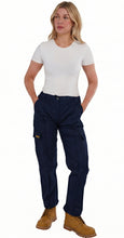 Woman wearing navy blue work pants and a white shirt on a white background